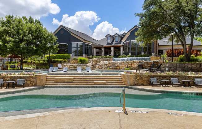 a swimming pool with a house in the background at The Vista on Brodie, Texas