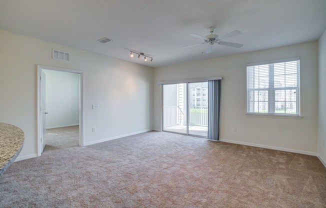 a bedroom with a ceiling fan and a door leading to a balcony