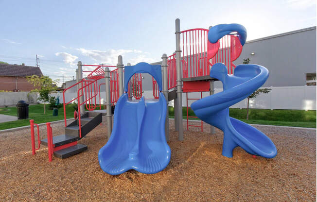 a playground with a blue slide and a red