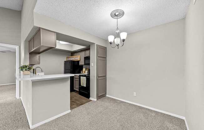 A kitchen area with a white counter and a refrigerator.