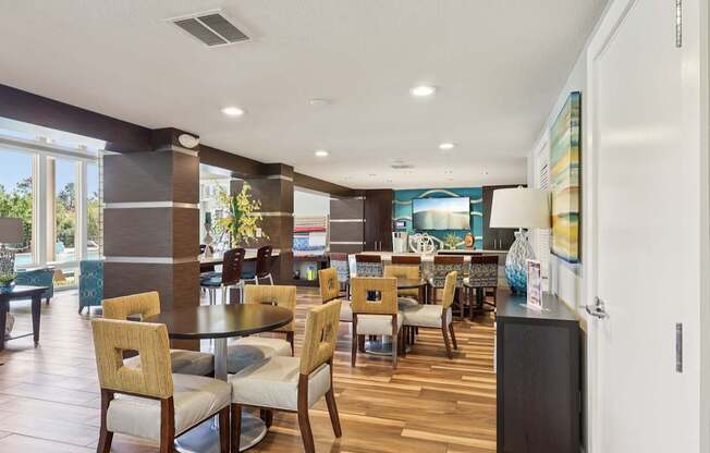 A dining room with a table surrounded by chairs.