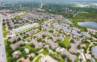 an aerial view of a neighborhood with houses and a lake