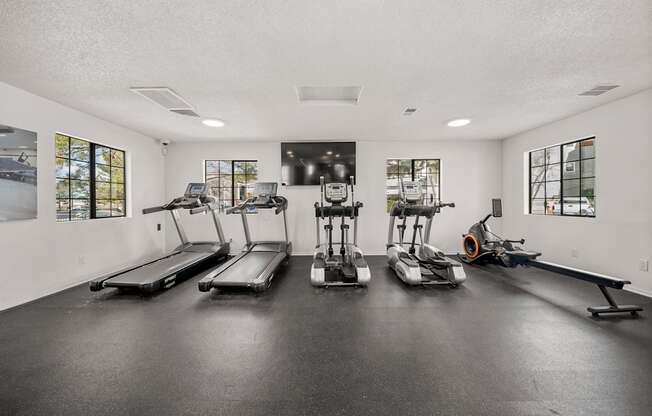 A gym with treadmills, elliptical machines, and a rowing machine.