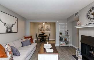 A living room with a couch, a fireplace, and a painting of a bull on the wall.