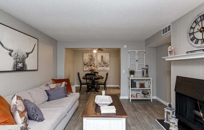 A living room with a couch, a fireplace, and a painting of a bull on the wall.