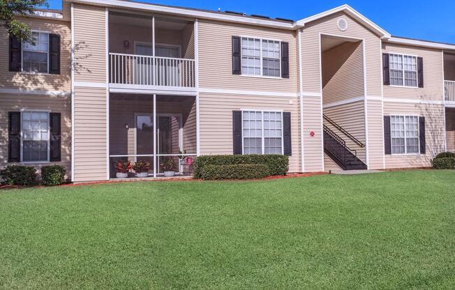 a house with a lawn in front of a brick building