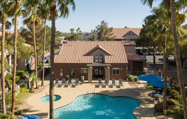 a house with a pool and chairs in front of it