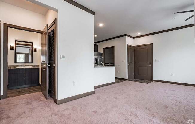 A room with a carpeted floor and a white wall with a brown door.