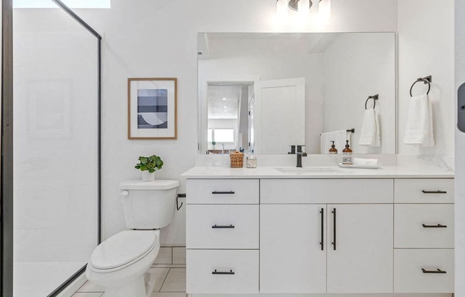 a white bathroom with a toilet and a sink