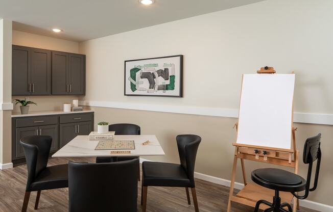 a dining room with a table and chairs and a white board on a easel