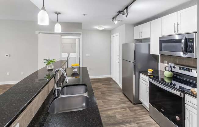 A modern kitchen with stainless steel appliances and a black countertop. at West Inman Lofts, Georgia, 30312