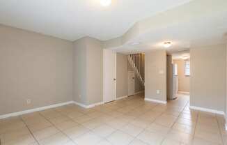 a living room with a tiled floor and a staircase in the background at Del Rio Apartment