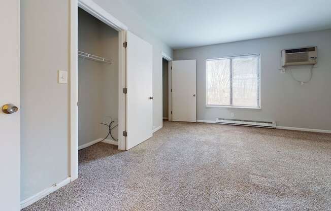 an empty room with a closet and a window