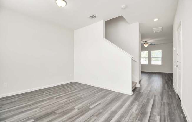 A room with a wooden floor and a staircase.