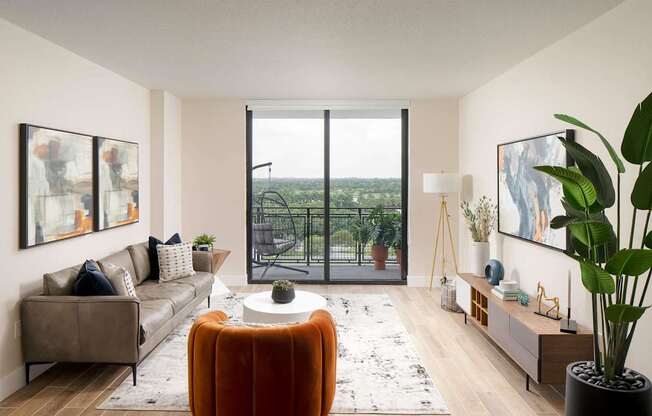 A living room with a large window overlooking a balcony with a view of the ocean. at Palma, Florida