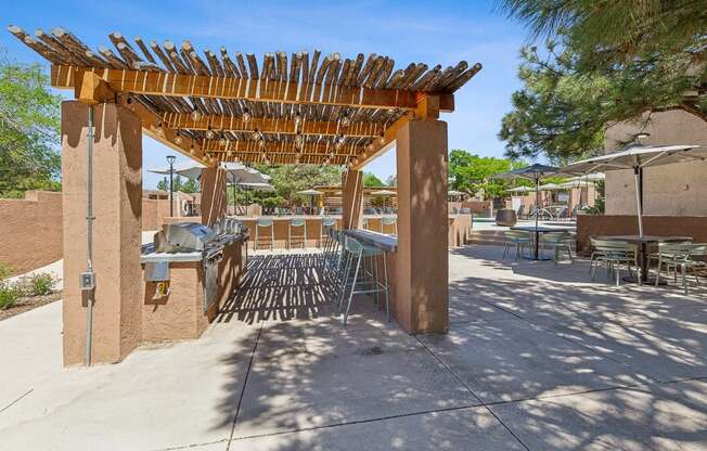 a patio with tables and chairs and a pergola at Acacia Gardens, Albuquerque, NM, 87111