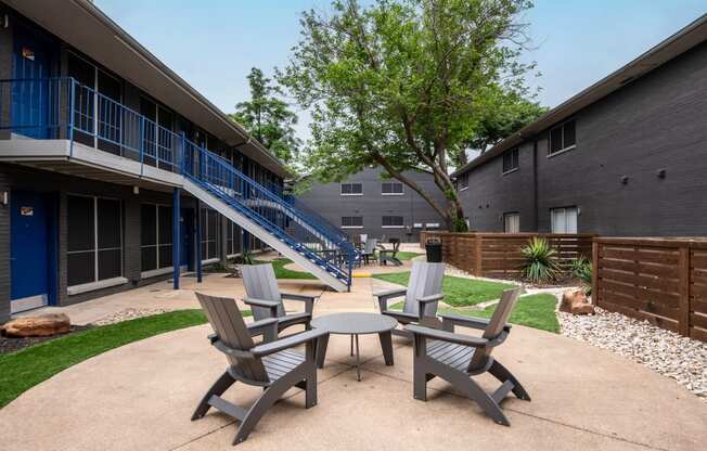 Patio between buildings at Stadium 700 Apartments in Arlington, TX with patio chairs and table on concrete pad