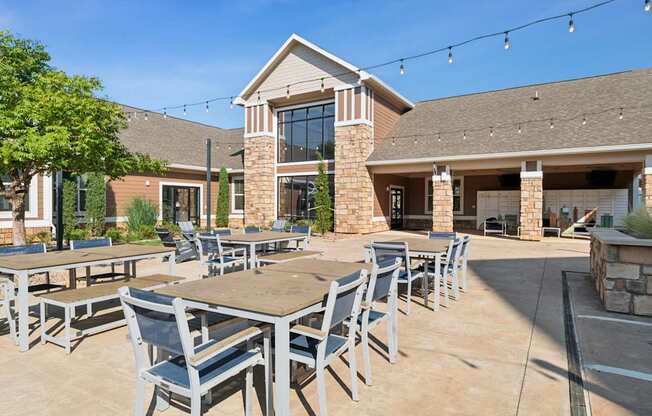 A patio with tables and chairs is set up outside a building.