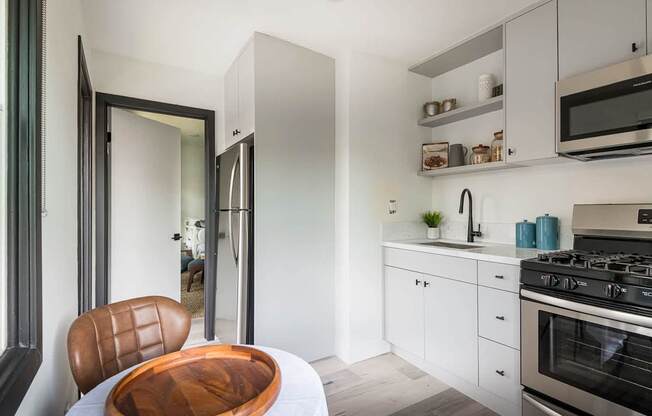 A modern kitchen with a wooden chair and a stove.