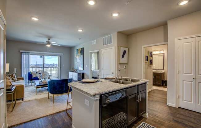 a kitchen with an island and a living room in the background