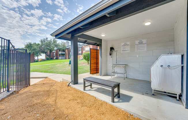 a covered patio with a hot tub and a wooden bench