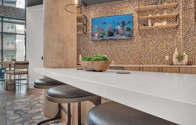 a kitchen with a long white counter and stools