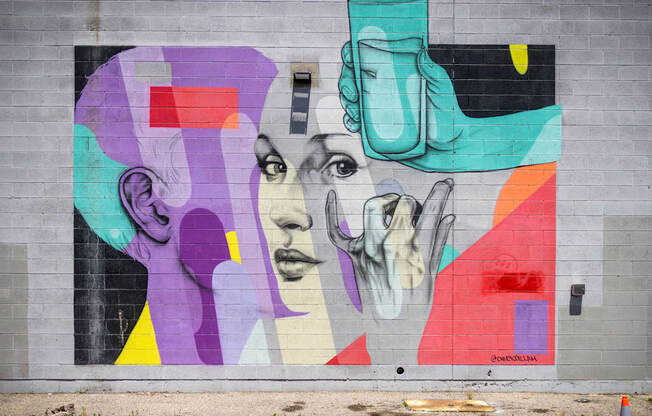 A colorful mural of a woman's face with a vase on her head.