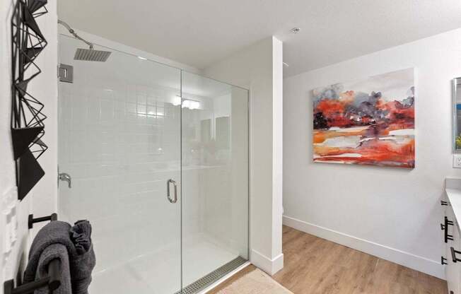 A bathroom with a glass shower door and a towel hanging on a rack.