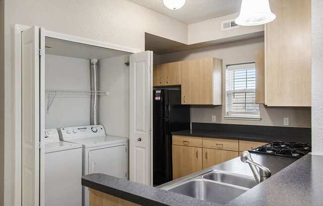 A kitchen with a window and washer and dryer at Lynbrook Apartments and Townhomes, Elkhorn, NE, 68022