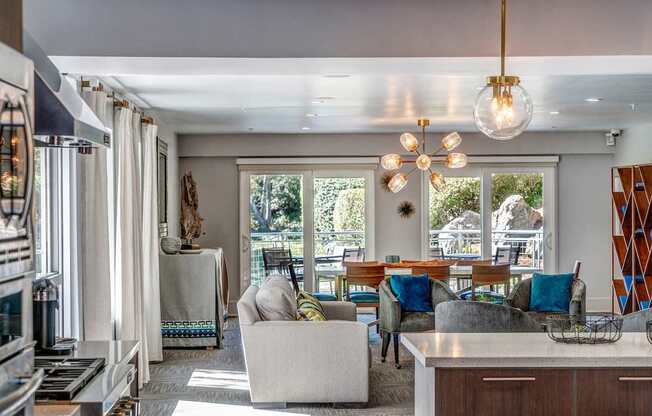A modern living room with a large window and a dining area.