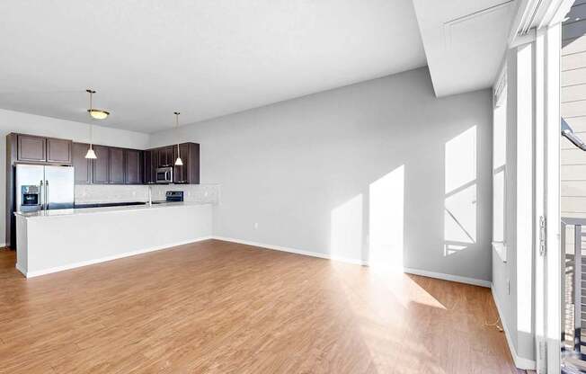 A spacious room with wooden flooring and white walls.