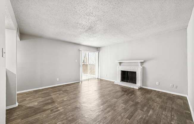 A room with a fireplace and wood flooring.