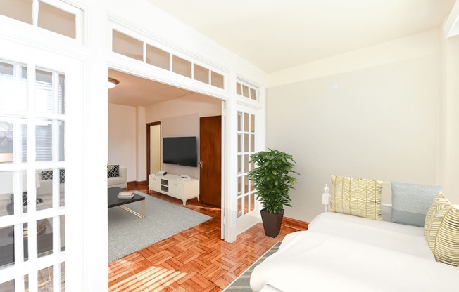 living area with sofa, coffee table, hardwood floors and view of sunroom at eddystone apartments in washington dc