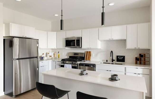 A modern kitchen with white cabinets and a stainless steel refrigerator.