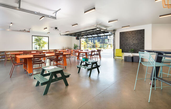 a room with tables and chairs and a chalkboard on the wall