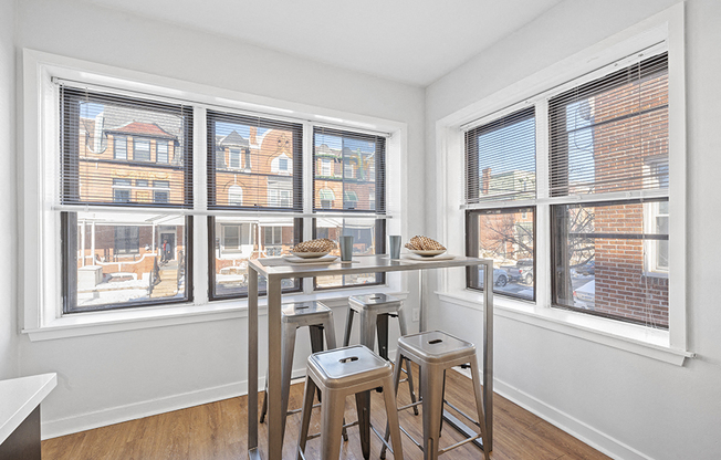Table and barstools in corner of kitchen with large windows with city view of University City in Philadelphia