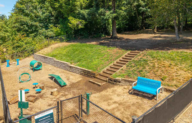 A playground with a blue slide and a green slide.