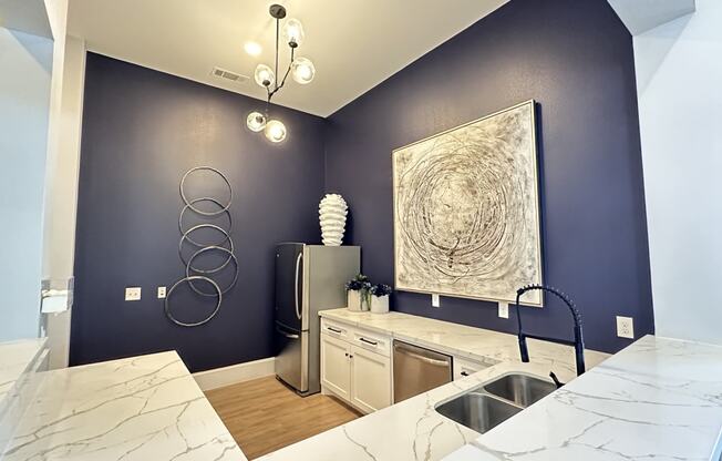 a bathroom with blue walls and a marble counter top and a sink