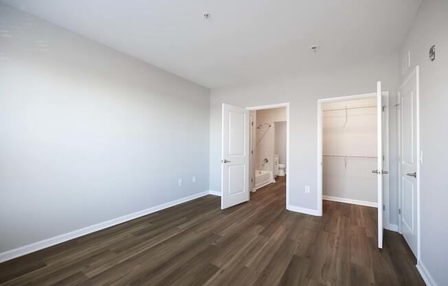 A room with white walls and wood flooring, with two open doors. at Harbor Pointe, New Jersey, 07002