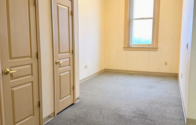 an empty room with a door and a window