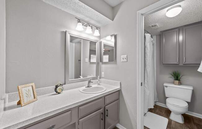 A bathroom with a white sink and a white toilet.