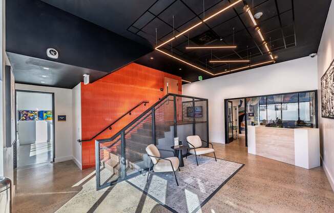 A modern office lobby with a staircase and a glass railing.