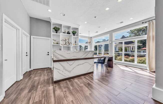 a kitchen with a marble counter top and a large window