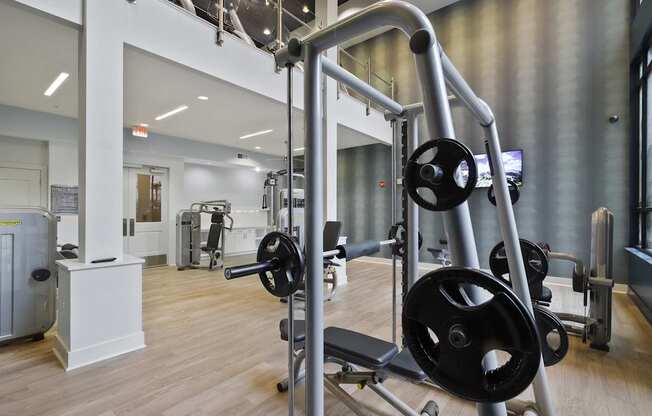 A gym with a variety of equipment including a squat rack.
