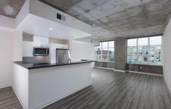 Kitchen with stainless steel appliances and living area with large windows