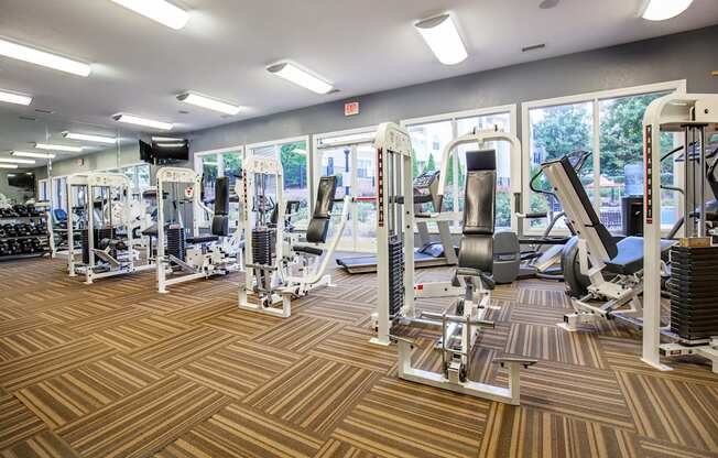 a gym with cardio machines and weights on a wooden floor