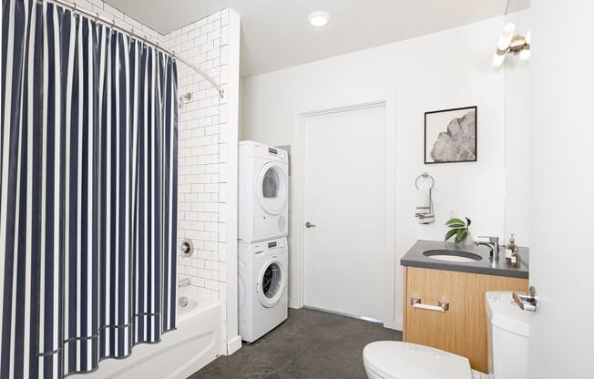 Bathroom with a washing machine and a toilet