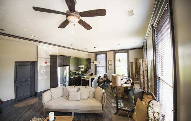 a living room and kitchen with a couch and a ceiling fan at The Knights @ 506 Delaware Apartments, New York