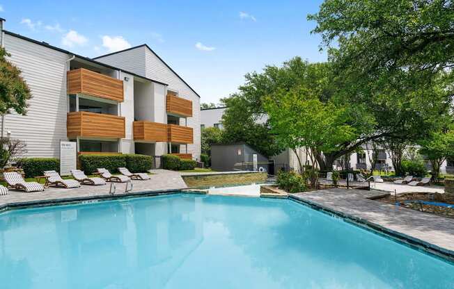 a swimming pool in front of a building with a resort style pool