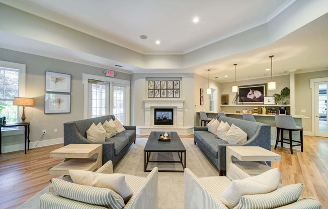 a living room with couches and a coffee table in front of a fireplace